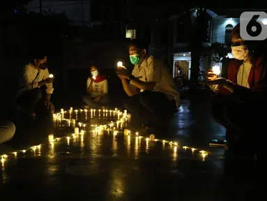 Sejumlah relawan menyalakan lampu pada malam renungan Hari AIDS Sedunia di Tanah Abang, Jakarta, Rabu (1/12/2021). Acara ini digelar secara gabungan oleh lembaga dan relawan pendamping orang dengan HIV/AIDS (ODHA). (Liputan6.com/Herman Zakharia)