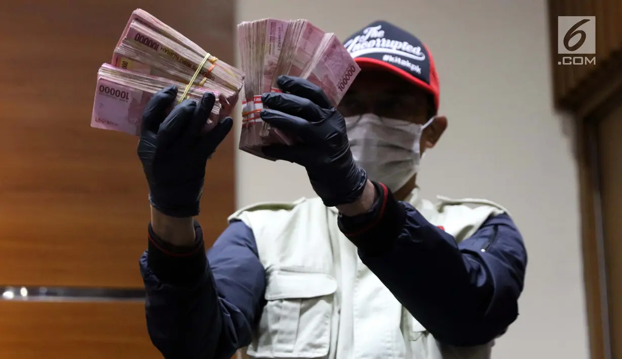 Petugas KPK menunjukkan barang bukti hasil Operasi Tangkap Tangan (OTT) terkait pengisian jabatan perangkat daerah di lingkungan Pemkab Kudus, Gedung KPK Jakarta, Sabtu (27/7/2019). KPK menetapkan tiga tersangka, salah satu diantaranya Bupati Kudus, M Tamzil. (Liputan6.com/Helmi Fithriansyah)