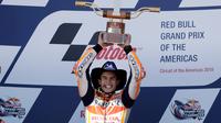 Pembalap Repsol Honda, Marc Marquez mengangkat trofi juara MotoGP Amerika di Circuit of the Americas (COTA), Austin, Minggu (22/4). Sebelum lomba, Marquez kena hukuman mundur tiga posisi karena melakukan pelanggaran di sesi kualifikasi. (AP/Eric Gay)
