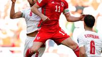 Pemain Iran Morteza Pouraliganji (kiri) berebut bola dengan pemain Wales Gareth Bale pada pertandingan sepak bola Grup B Piala Dunia 2022 di Stadion Ahmad Bin Ali, Al Rayyan, Qatar, Jumat (25/11/2022). Iran mengalahkan Wales dengan skor 2-0. (AP Photo/Francisco Seco)