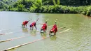 Foto dari udara sejumlah wanita melakukan aksi meniti satu bambu di atas air di Chishui, Provinsi Guizhou, China pada 25 Juni 2020. Seni meniti satu bambu dari Guizhou ini mengharuskan seseorang untuk berdiri atau duduk di atas sebatang bambu sembari melakukan gerakan keseimbanga. (Xinhua/Tao Liang)