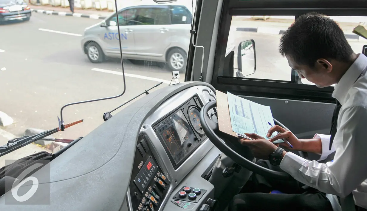 Pramudi bus Transjakarta mengisi data saat tiba di halte busway Pasar Baru, Jakarta, Kamis (26/5/2016). Transjakarta perluasan wilayah cakupan rute hingga ke Kota Tangerang. (Liputan6.com/Yoppy Renato)