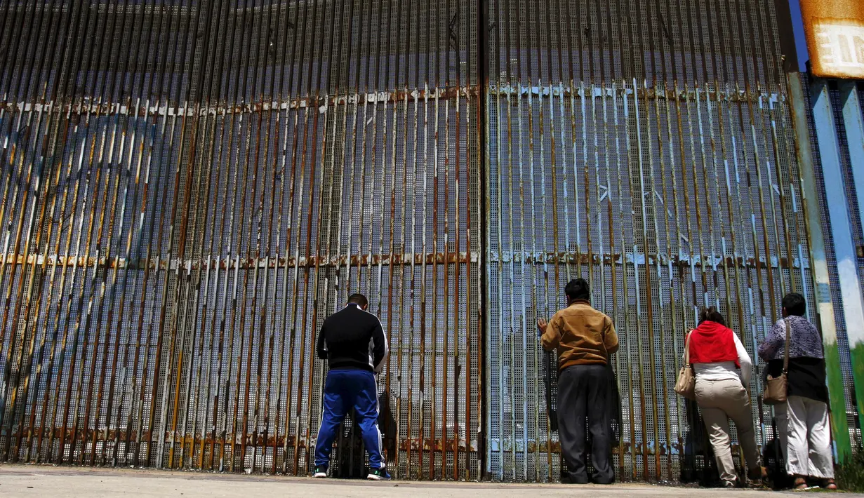 Sejumlah warga tampak menunggu untuk bertemu keluarganya di pagar perbatasan antara Meksiko dan Amerika Serikat, Playas Tijuana, Meksiko, (12/4). Tembok ini memisahkan antara Meksiko dan Amerika Serikat. (REUTERS / Jorge Duenes)