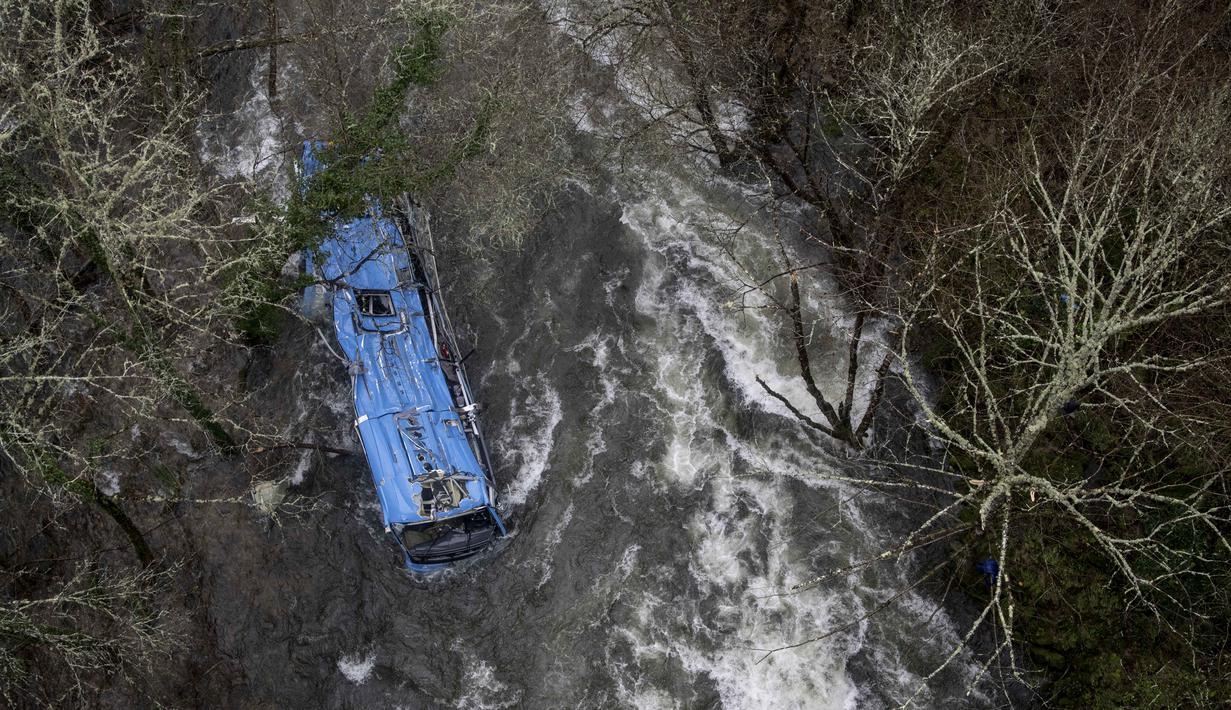 Bangkai bus terlihat di sungai Lerez setelah jatuh saat melintasi jembatan, menewaskan empat orang, di Cerdedo-Cotobade, Spanyol (25/12/2022). Kecelakaan itu terjadi pada 24 Desember malam di dekat Vigo dan perbatasan dengan Portugal. (AFP/Brais Lorenzo)
