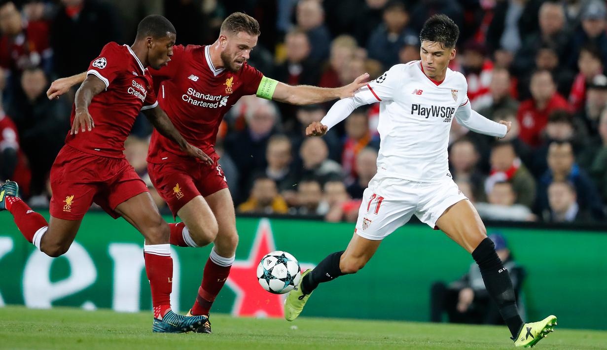 Pemain Sevilla, Joaquin Correa berusaaa merebut bola dari pemain Liverpool, Joe Gomez dan Jordan Henderson pada laga Grup E Liga Champions di Stadion Anfield, Rabu (13/9). Sevilla berhasil menahan imbang Liverpool dengan skor 2-2 (AP Photo/Frank Augstein)