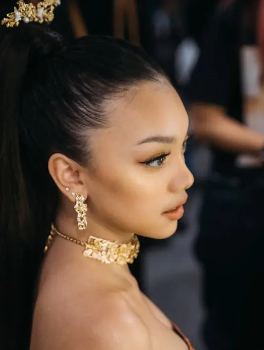 Untuk makeup ia pun mengenakan riasan glam serba orange dari riasan mata dan lipstiknya. Naura melengkapi penampilan dengan aksesori keemasannya.  Credit: (@naura.ayu)