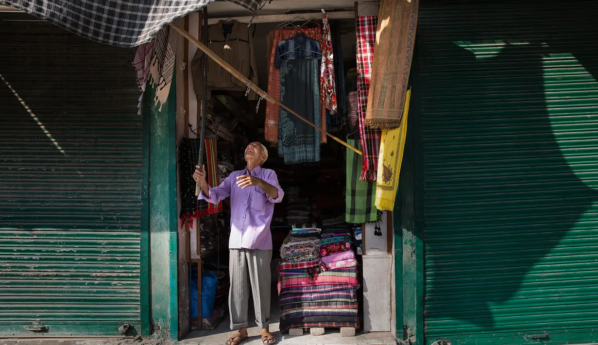 Seorang penjaga toko membuka tokonya di sebuah pasar di Kota Anantnag, sekitar 60 kilometer sebelah selatan Kota Srinagar, ibu kota musim panas Kashmir yang dikuasai India, pada 17 Agustus 2020. (Xinhua/Javed Dar)