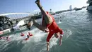 Seorang peserta mengenakan kostum Sinterklas terjun dengan cara salto dalam perlombaan renang bertajuk Copa Nadal (Piala Natal) edisi ke-115 yang berlangsung di Port Vell, Barcelona, Spanyol, Rabu (25/12/2024). Ajang tersebut diikuti oleh 450 peserta dengan jarak renang sejauh 200 meter. (AFP/Josep Lago)