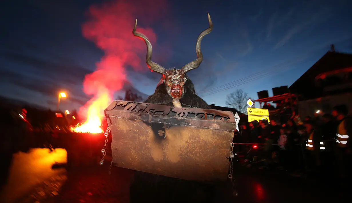 Seorang pria berpakaian seperti Krampus, mahkluk setengah kambing dan setengah iblis, dalam sebuah acara di Boerwang, 24 November 2018. Krampus merupakan legenda tradisi Natal di Jerman untuk menakuti anak-anak yang nakal. (KARL-JOSEF HILDENBRAND/DPA/AFP)