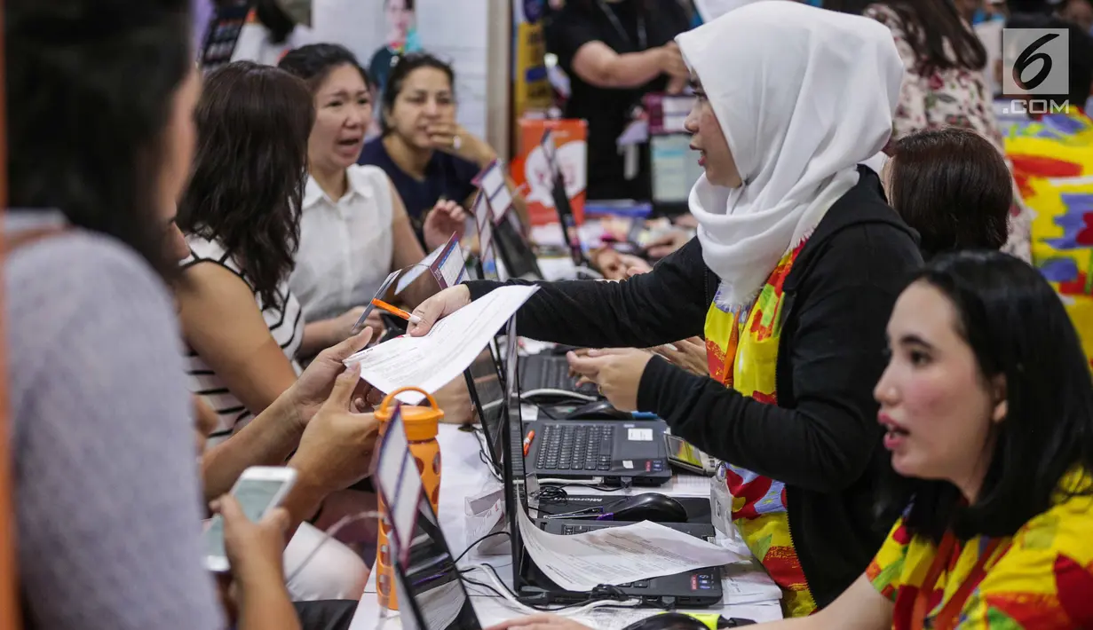 Pekerja melayani pengunjung yang memadati gerai perjalanan wisata dalam acara Astindo Travel Fair 2019 di JCC Senayan, Jakarta, Jumat (22/2). Astindo Travel Fair 2019 digelar pada 22 hingga 24 Februari 2019. (Liputan6.com/Faizal Fanani)