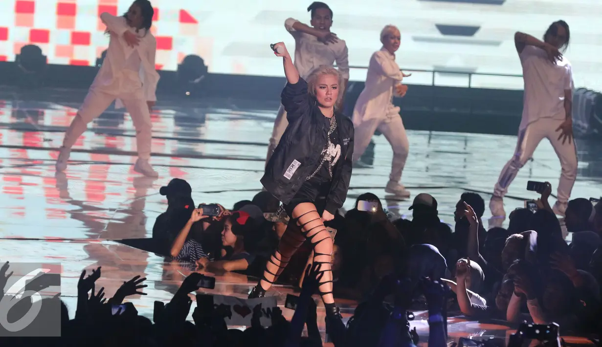 Agnez Mo mengajak penonton untuk bernyanyi saat tampil di panggung HUT 26 SCTV, Jakarta, Rabu (24/8). SCTV menampilkan artis-artis papan atas saat Malam Puncak di Senayan. (Liputan6.com/Herman Zakharia)