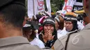 Salah satu massa tampak menangis saat menggelar aksi unjuk rasa di depan Istana Merdeka, Jakarta, Selasa (7/4/2015). Mereka menagih janji Presiden Jokowi mencabut moratorium terkait larangan pengiriman TKI ke Timur Tengah. (Liputan6.com/Faizal Fanani)