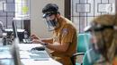 Petugas loket lengkap dengan masker dan face shield sedang mengetik saat proses pembuatan KTP Elektronik di Kecamatan Pamulang, Tangerang Selatan, Senin (15/6/2020). Dukcapil Tangsel membuka layanan rekaman E-KTP jelang Pilkada dengan menerapkan ketentuan New Normal. (Liputan6.com/Fery Pradolo)