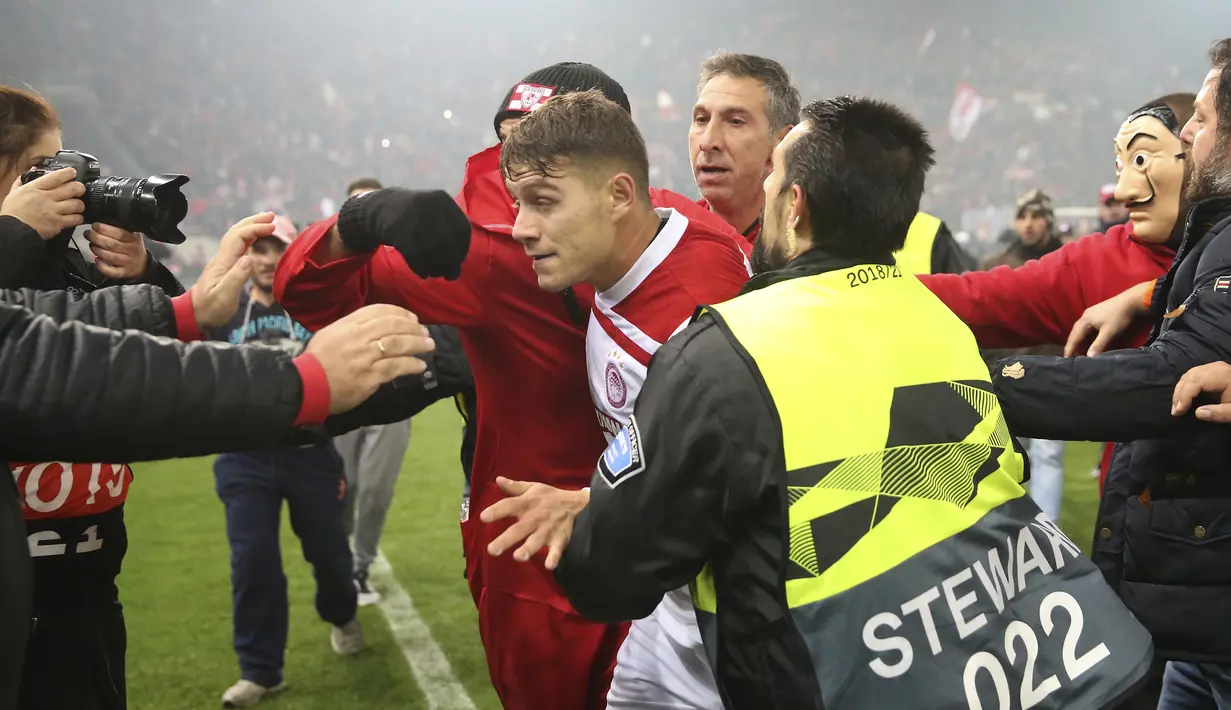 Para pemain Olympiakos, Leonardo Koutris, meninggalkan lapangan usai merayakan kemenangan atas AC Milan pada laga Europa di Stadion Georgios Karaiskakis, Athena, Kamis (13/12). Olympiakos menang 3-1 atas AC Milan. (AP/Thanassis Stavrakis)