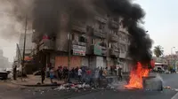Pengunjuk rasa antipemerintah membakar sejumlah benda dan memblokir jalan saat menggelar protes di Baghdad, Irak, Rabu (2/10/2019). Pengunjuk rasa menginginkan pekerjaan dan layanan publik yang lebih baik. (AP Photo/Hadi Mizban)