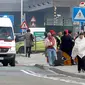 Calon penumpang mengenakan selimut berjalan meninggalkan lokasi ledakan di Bandara Zaventem dekat Brussels, Belgia, (22/3). Sedikitnya 13 orang tewas akibat ledakan beruntun yang mengguncang ruang keberangkatan bandara. (REUTERS / Francois Lenoir)