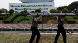 Personel kepolisian bergotong-royong memasang tenda sebagai persiapan pengamanan pelantikan Jokowi-JK sebagai presiden dan wakil presiden di gedung parlemen tersebut, Jakarta, (15/10/14). (Liputan6.com/Andrian M Tunay)