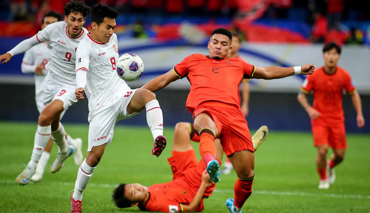 Pemain timnas Indonesia, Witan Sulaeman (kedua kiri) berebut bola dengan Jiang Guangtai (kedua kanan) saat kualifikasi Piala Dunia FIFA 2026 zona Asia melawan China di Qingdao, provinsi Shandong, China timur, pada Selasa 15 Oktober 2024. (Foto oleh AFP/China OUT)