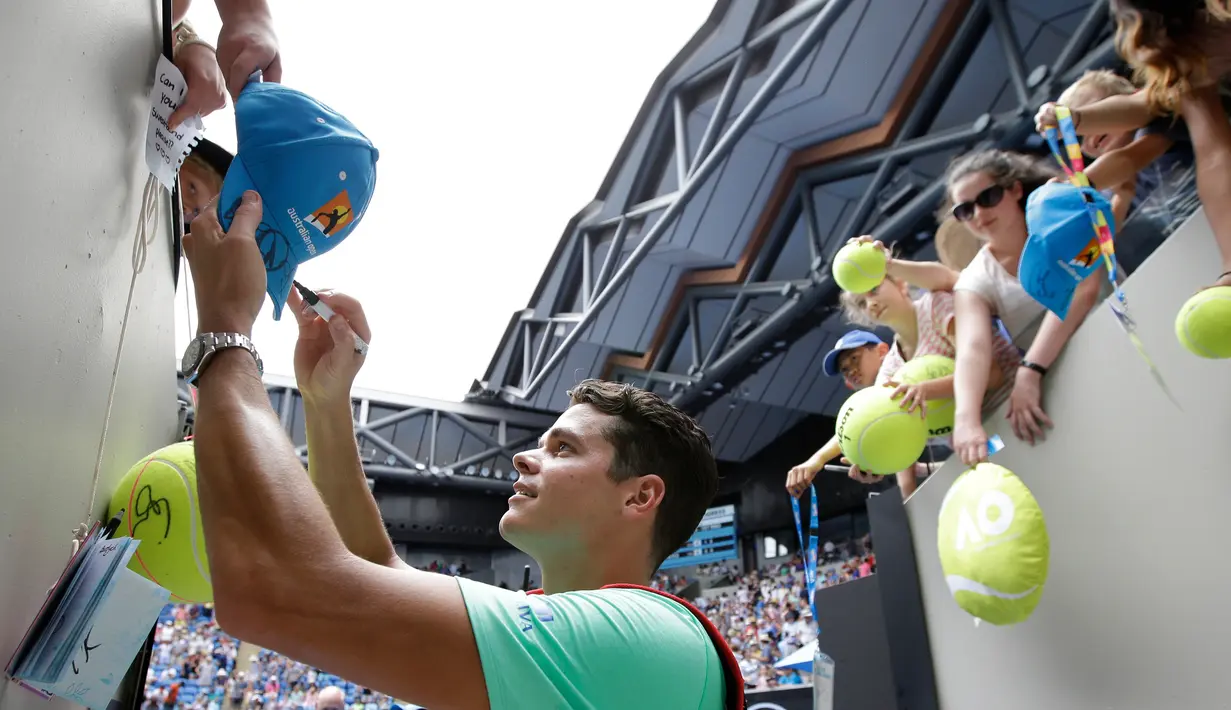 Petenis asal Kanada Milos Raonic membubuhkan tanda tangan di topi penggemarnya setelah memenangkan pertandingan putaran kedua Australia Terbuka melawan petenis Jerman Dustin Brown di Melbourne, 17 Januari 2017. (AP Photo/Aaron Favila)