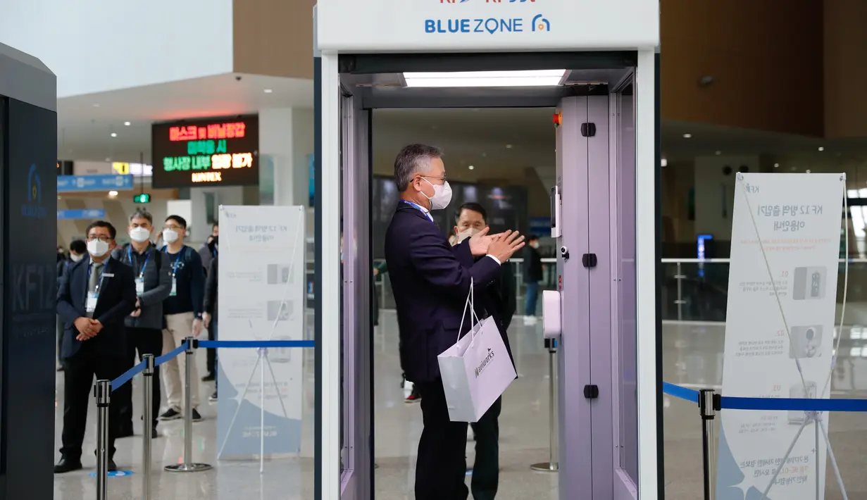 Pengunjung melewati bilik disinfeksi mobile sebelum memasuki ruang pameran di Korea International Exhibition Center di Goyang (18/11/2020). Korsel memutuskan untuk menaikkan satu level dari lima tingkat aturan social distancing di tengah melonjaknya kembali infeksi COVID-19. (Xinhua/Wang Jingqiang)