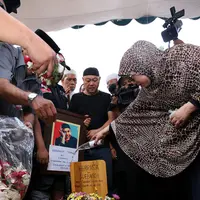 Sang istri, Utami terlihat menyiramkan air pada tempat peristirahatan terakhir suaminya. (Galih W Satria/Bintang.com)