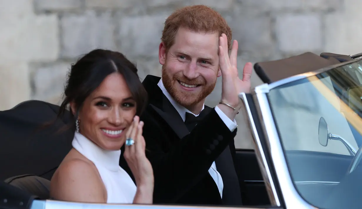 Pangeran Harry dan istrinya Meghan Markle tersenyum saat meninggalkan Kastil Windsor untuk ke acara resepsi dekat Frogmore House (19/5). Mobil yang dikenderai Pangeran Harry yaitu Jaguar Classic E-Type Concept Zero.  (AFP Photo/Pool/Steve Parsons)