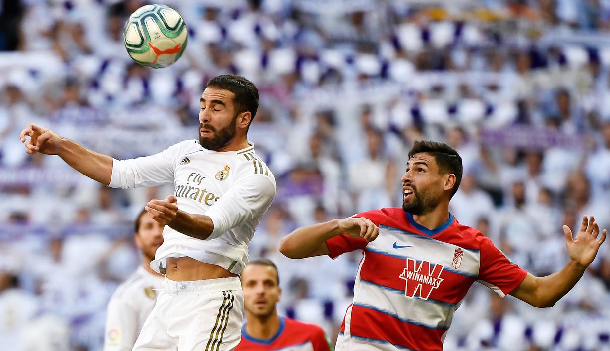 Bek Real Madrid, Dani Carvajal, menyundul bola saat melawan Granada pada laga La Liga Spanyol di Stadion Santiago Bernabeu, Madrid, Sabtu (5/10). Madrid menang 4-2 atas Granada. (AFP/Pierre-Philippe Marcou)