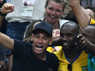 Aksi Neymar (kir)  saat mendukung timnas voli Brasil berlaga pada final bola voli Olimpiade Rio 2016 melawan Italia di Stadion Maracanazinho, Rio de Janeiro, (21/8/2016). (AFP/Johannes Eisele)