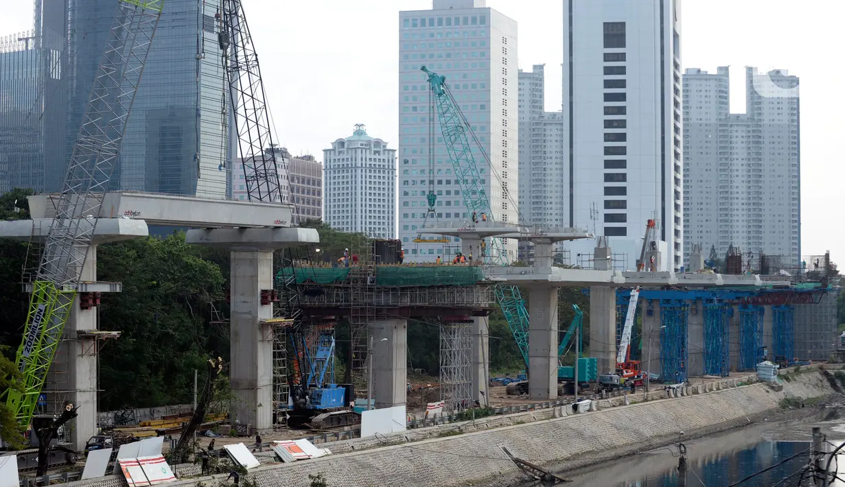 Para pekerja sedang menyelesaikan bentangan beton panjang light rail transit (LRT) di tikungan Jembatan 66 Kuningan-Dukuh Atas, Jakarta, Senin (6/7/2020). (merdeka.com/Dwi Narwoko)