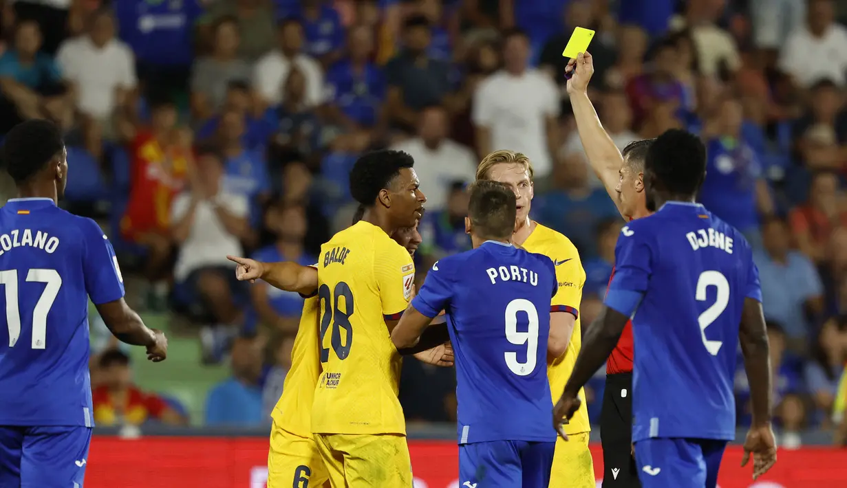 Wasit Cesar Soto Grado memberikan kartu kuning kepada pemain Barcelona, Gavi setelah melakukan pelanggaran kepada pemain Getafe saat laga pekan pertama Liga Spanyol 2023/2024 melawan Getafe di Coliseum Alfonso Perez Stadium, Getafe, Spanyol, 14 Agustus 2023 WIB. (AFP/Javier Soriano)
