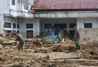 Tumpukan-tumpukan kayu gelondongan ini merupakan material yang terbawa arus banjir bandang yang terjadi Selasa (25/11/2025) lalu. Tampak dalam foto, personel Tentara Nasional Indonesia (TNI) mencari korban banjir di Batang Toru, Sumatra Utara, Selasa 2 Desember 2025. (AP Photo/Binsar Bakkara)