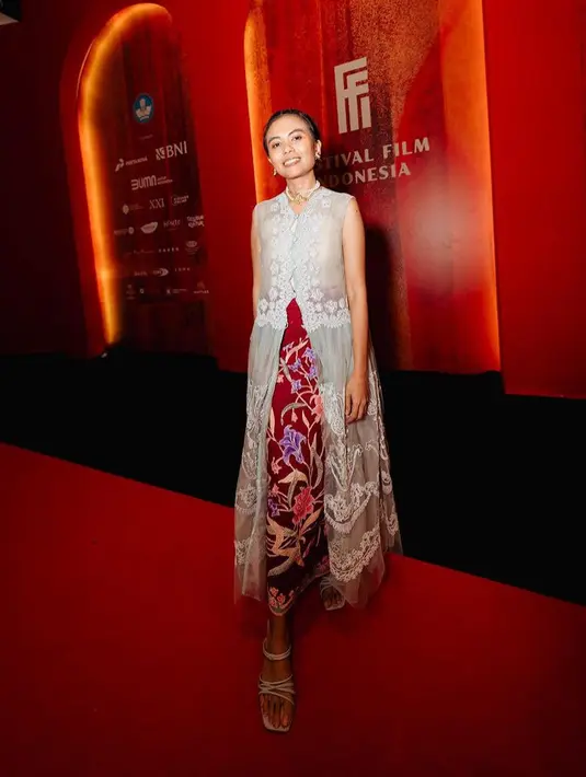 Kamila Andini Sutradara Gadis Kretek tampil dengan atasan panjang silver tanpa lengan dipadukan kain batik merah sebagai bawahannya. [@kamilaandini]