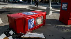Sebuah kotak surat kabar Village Voice tergeletak di samping tempat sampah di Manhattan, AS (22/8). Village Voice  adalah surat kabar mingguan tertua dan paling terkenal di AS. (Drew Angerer/Getty Images/AFP)