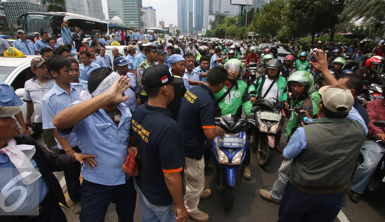 Ratusan pengendara Go-Jek terlibat kericuhan dengan sopir taksi di Jakarta, Selasa (22/3). Ratusan Go-Jek mendatangi para sopir taksi karena tersebar isu pemukulan terhadap beberapa pengendara Go-Jek oleh sopir taksi.  (Liputan6.com/Immanuel Antonius)