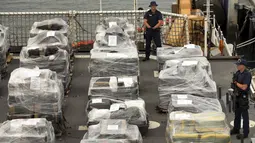 Anggota US Coast Guard berjaga di dekat 33 ton kokain senilai sekitar Rp 13 triliun lebih, di California, Senin (10/8/2015). Kokain tersebut disita dari kapal semi-sumbersible di timur Samudera Pasifik pada Kamis (6/8). (REUTERS/Mike Blake)
