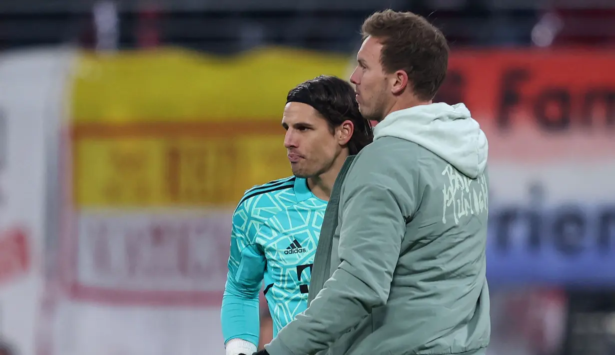 Pelatih Bayern Munchen, Julian Nagelsmann, memberikan arahan kepada Yann Sommer saat melawan RB Leipzig pada laga Bundesliga di Stadion Red Bull Arena, Sabtu (21/1/2023). Namun, debut Yann Sommer tidak maksimal karena gawang yang dijaganya tidak steril dari gol. (AFP/Ronny Hartmann)