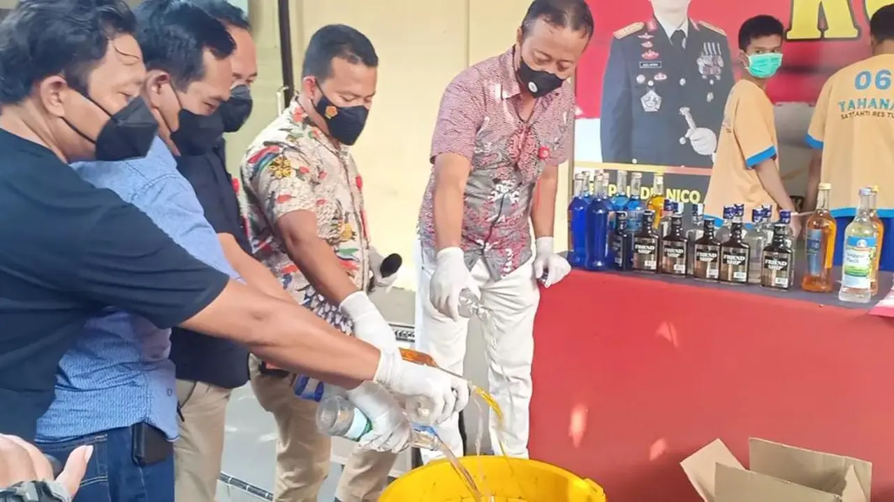 Anggota ketika memusnahkan miras di Mapolres Tuban. (Liputan6.com/Ahmad Adirin)