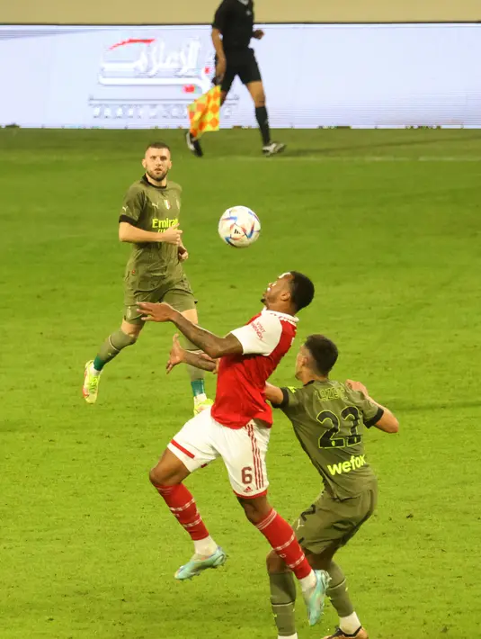 Bek Arsenal, Gabriel Magalhaes berebut bola dengan penyerang AC Milan, Marko Lazetic selama pertandingan Dubai Super Cup 2022 di di stadion al-Maktoum di Uni Emirat Arab (13/12/2022). Arsenal menang tipis atas AC Milan dengan skor 2-1. (AFP/Karim Sahib)