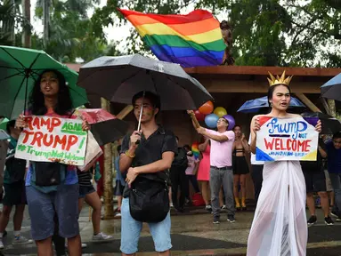 Kelompok LGBT bersorak saat menggelar unjuk rasa menolak kedatangan Presiden AS Donald Trump saat demonstrasi di dalam kampus universitas negeri di kota Los Banos, provinsi Laguna, Manila, Filipina (9/11). (AFP Photo/Ted Aljibe)