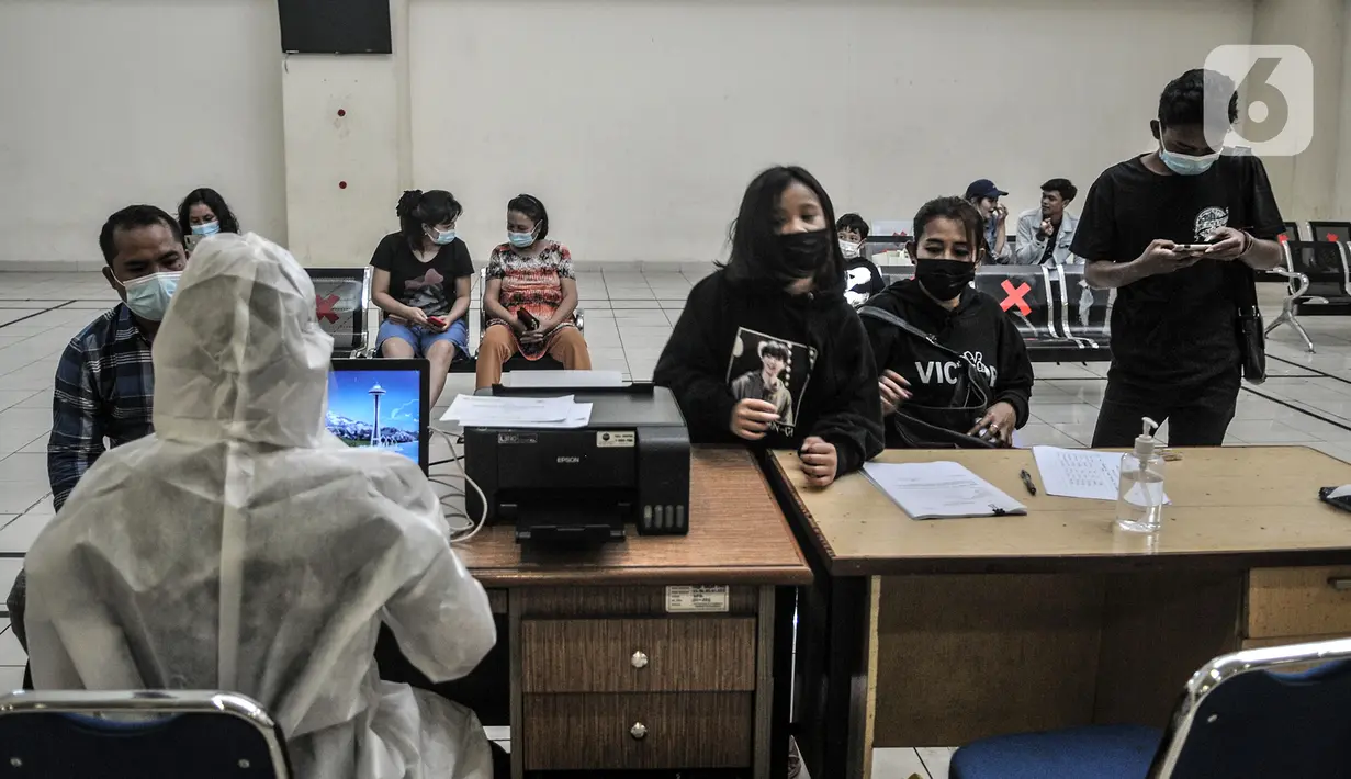 Tenaga kesehatan mendata calon penumpang bus antarkota antarprovinsi (AKAP) yang akan menjalani rapid test antigen COVID-19 di Terminal Pulogebang, Jakarta, Rabu (30/12/2020). Layanan ini dimulai sejak pukul 08.00 WIB hingga 19.00 WIB. (merdeka.com/Iqbal S. Nugroho)