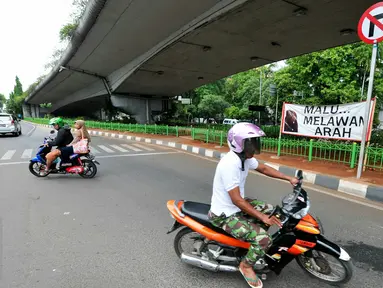 Aksi pemotor melawan arus masih saja terjadi meski sudah terpasang spanduk besar larangan melawan arus di putaran Kalibata, Jakarta, Rabu (16/12/2015). (Liputan6.com/Yoppy Renato)