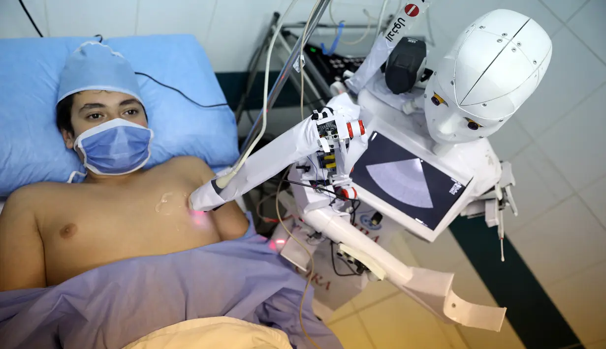 Robot Cira 03 melakukan pemeriksaan ekokardiogram terhadap seorang sukarelawan di sebuah rumah sakit di Kota Tanta, Provinsi Gharbiya, Mesir, 3 Desember 2020. Sebuah robot putih berbentuk manusia berjalan di koridor bangsal darurat sebuah rumah sakit swasta di Kota Tanta. (Xinhua/Ahmed Gomaa)