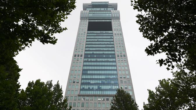 Gedung pencakar langit Pangu Plaza yang mendominasi daerah di seberang Stadion Olimpiade Bird's Nest, Beijing, Selasa (20/7/2019). Gedung yang pernah masuk dalam film Transformers: Age of Extinction itu terjual dalam lelang online dengan harga 734 juta USD (sekitar Rp10,5 triliun). (GREG BAKER/AFP)