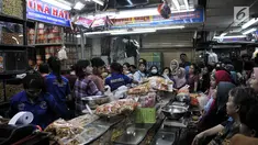 Puluhan pembeli antre untuk mendapatkan kue kering untuk Lebaran di Pasar Jatinegara, Jakarta, Selasa (5/6). Meskipun Idul Fitri masih dua pekan lagi, namun toko kue kering di Pasar Jatinegara mulai diserbu pembeli. (Merdeka.com/ Iqbal S. Nugroho)