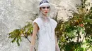 Model berpose di catwalk saat memamerkan koleksi Spring/Summer 2018 untuk Chanel selama Paris Fashion Week, Selasa (3/10). Gaya para model tersebut dilengkapi dengan sepatu, topi, sarung tangan dan ponco plastik. (AP Photo/Francois Mori)