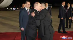 Setibanya di bandara, Putin disambut pelukan hangat Kim Jong Un. (STR / KCNA VIA KNS / AFP)