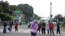 <p>Warga berfoto di halaman luar Monumen Nasional (Monas) Jakarta, Kamis (5/5/2022). Meski kawasan Monas masih ditutup sejak awal pandemi COVID-19 pada Maret 2020 lalu namun tidak menyurutkan minat warga untuk bisa berwisata yaitu dengan memanfaatkan kawasan luar monumen tersebut. (Liputan6.com/Faizal Fanani)</p>