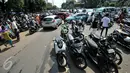 Kendaraan milik peziarah diparkir hingga memenuhi badan jalan depan TPU Karet Bivak, Jakarta, Rabu (6/7). Padatnya peziarah menyebabkan arus lalin di depan TPU menjadi tersendat karena warga memarkir kendaraan di badan jalan. (Liputan6.com/Yoppy Renato)