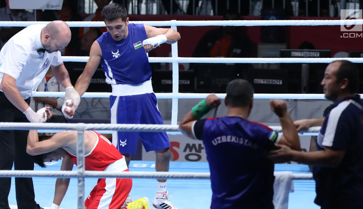 Petinju putra Indonesia, Sunan Agung Amoragam (kaus merah) usai melawan Mirazizbek Mirzakhalilov (Uzbekistan) pada semifinal bantam 56kg putra Asian Games 2018 di JIEXPO Kemayoran, Jumat (31/8). Amoragam kalah 0-5. (Liputan6.com/Helmi Fithriansyah)