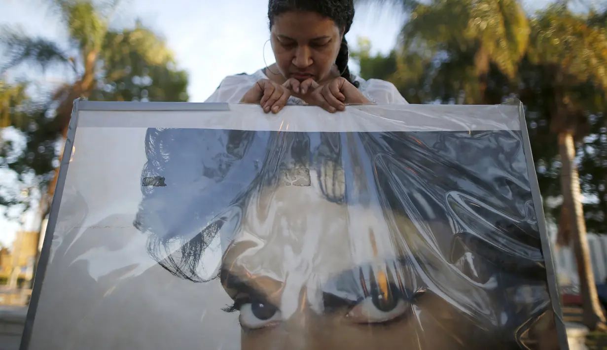 Penggemar memegang poster Prince saat mengenang dan memberi penghormatan bagi sang penyanyi legendaris itu di Los Angeels, California, Kamis (21/4). Pemilik nama lengkap Prince Rogers Nelson itu meninggal dunia pada usia 57 tahun. (REUTERS/Lucy Nicholson)
